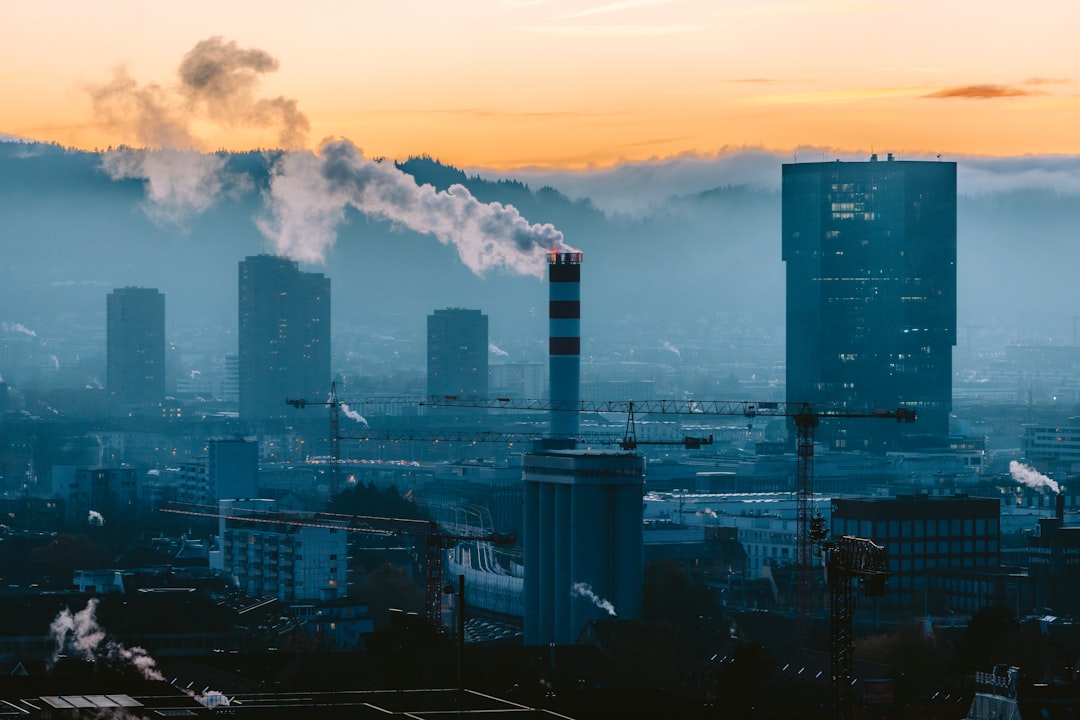 A view of a city with smoke coming out of the stacks